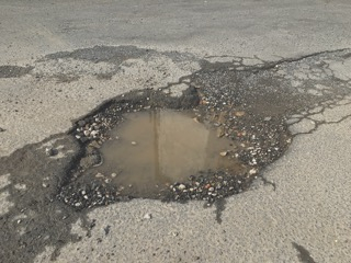A Pothole on a road filled with water